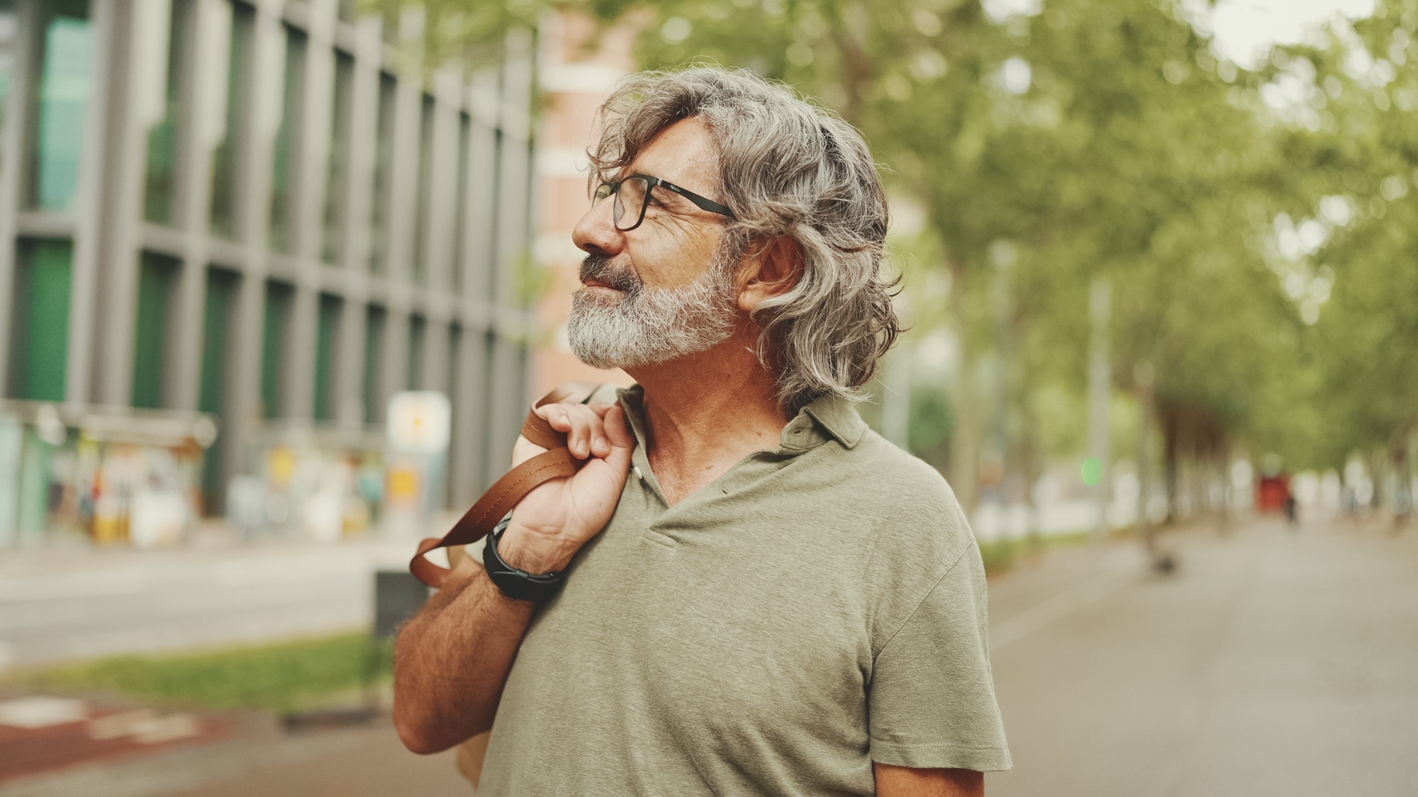 Middle-aged man with gray hair and beard walks